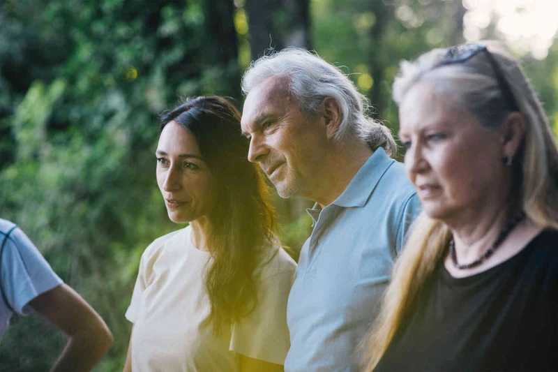 Eine Gruppe von Menschen stehen drau&szlig;en und h&ouml;ren zu