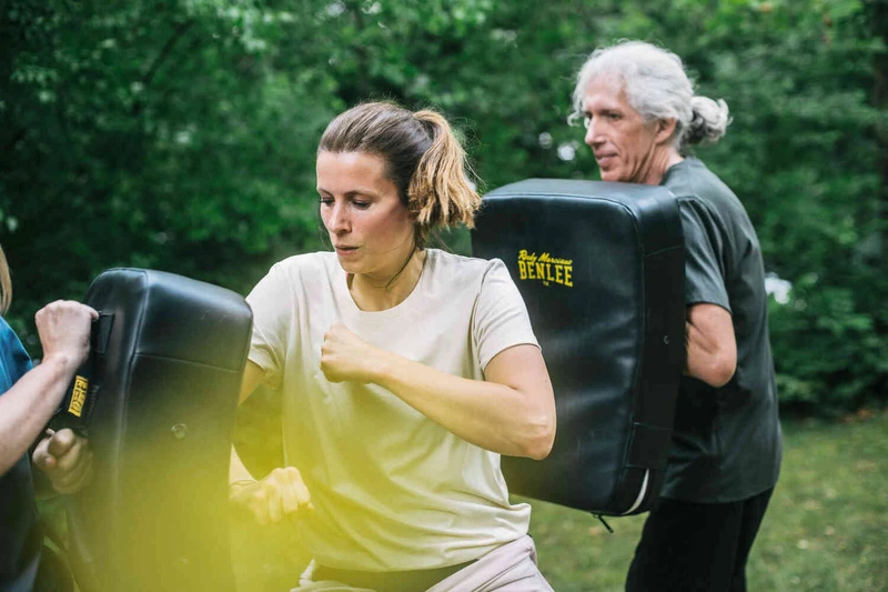 Frau schl&auml;gt gegen Box Sack in einer Gruppen&uuml;bung