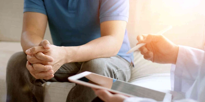 Nahaufnahme von den H&auml;nden eines Mannes der Therapie Fragen beantwortet.